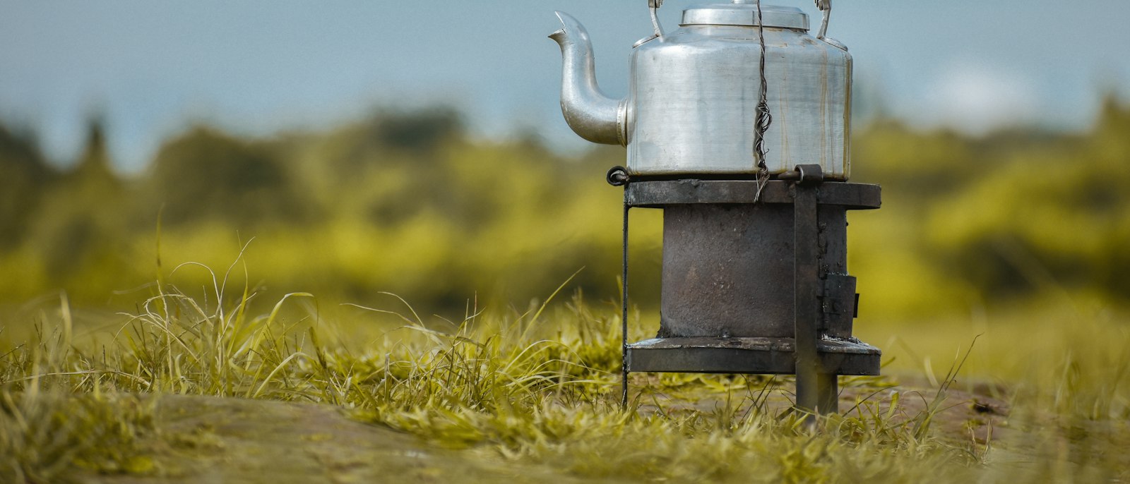 A white kettle heating on a black stove