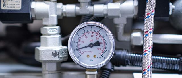 Close-up of an analog pressure gauge on a machine